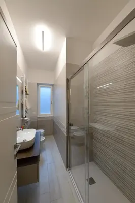 a bathroom with a glass shower and two toilets at San Pietro Moonlight Luxury Apartment in Rome