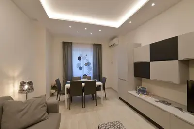 a living room with a table and a dining room at San Pietro Moonlight Luxury Apartment in Rome