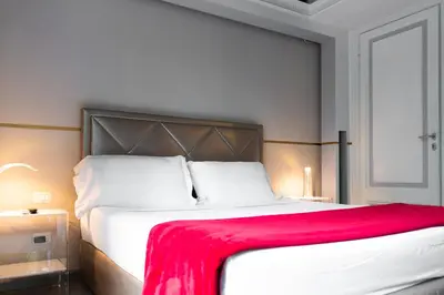 a bedroom with a large white bed with a red blanket at Luxury on the River in Rome