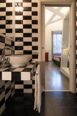 a bathroom with a black and white checkered wall at Luxury on the River in Rome