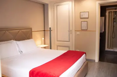 a bedroom with a large white bed with a red blanket at Luxury on the River in Rome