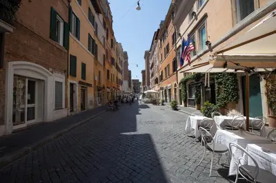 an empty street with tables and chairs and buildings at Borgo Pio 91 in Rome