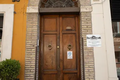 a wooden door on a building with a sign on it at Borgo Pio 91 in Rome