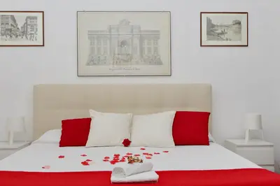 a bedroom with a red and white bed with roses on it at Sanctuary Home in Rome