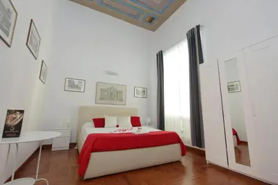 a white bedroom with a bed with a red blanket at Sanctuary Home in Rome