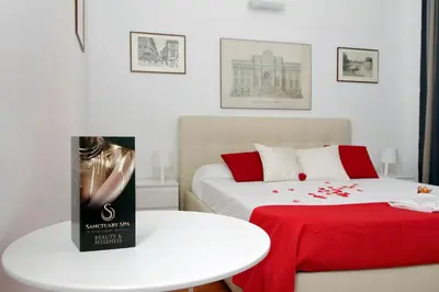 a room with two beds and a table with a book at Sanctuary Home in Rome