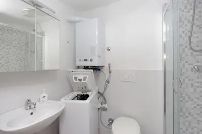 a white bathroom with a sink and a shower at Sanctuary Home in Rome