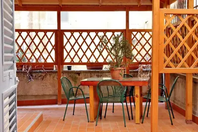 a wooden table and chairs on a patio at Sanctuary Home in Rome