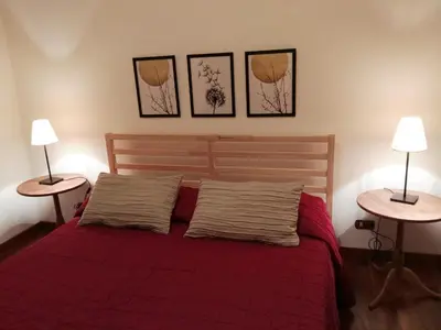 a bedroom with a red bed with two tables at Pigneto Suite appartamento 50 m da metro C in Rome