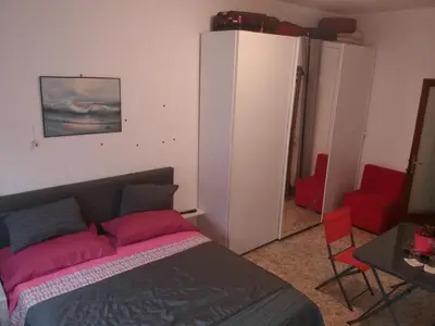 a bedroom with a bed and a red chair at Apartament Silvy Trastevere in Rome
