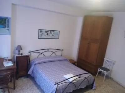 a bedroom with a bed and a wooden cabinet at Apartament Silvy Trastevere in Rome