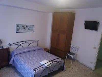 a bedroom with a bed and a cabinet and a television at Apartament Silvy Trastevere in Rome