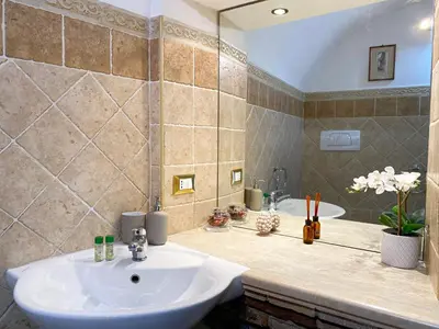 a bathroom with a white sink and a tub at Karma House Deluxe Navona in Rome