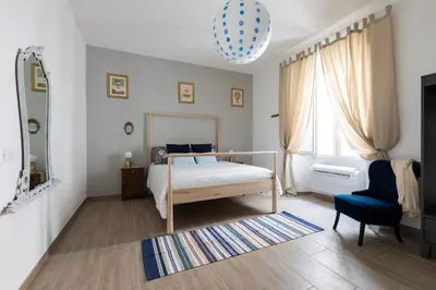 a bedroom with a bed and a blue chair at Casa Otto in Rome