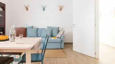 a living room with a blue couch and a table at Casa Otto in Rome