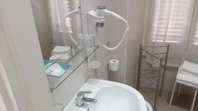 a white bathroom with a sink and a mirror at Vatican City Holidays Guesthouse in Rome