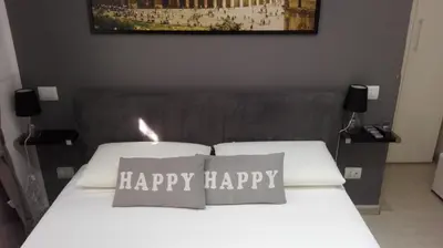 a bedroom with a white bed with two pillows with happy happy at Vatican City Holidays Guesthouse in Rome