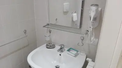 a white bathroom with a sink and a mirror at Vatican City Holidays Guesthouse in Rome