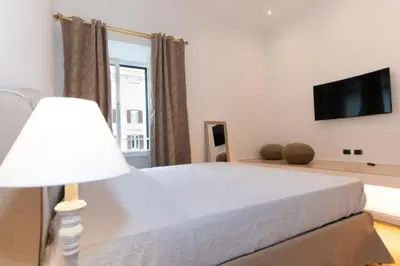 a bedroom with a bed and a flat screen tv at Luxury Laura Vatican Apartment ROMA CENTRO in Rome