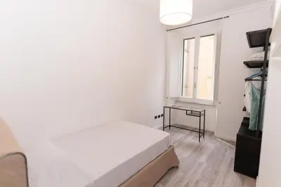 a white bedroom with a bed and a window at Luxury Laura Vatican Apartment ROMA CENTRO in Rome