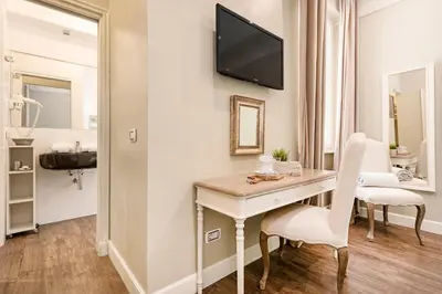 a room with a desk and a tv on the wall at Le Stanze Di Elle in Rome
