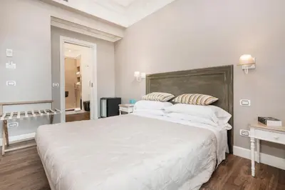 a white bedroom with a large white bed with pillows at Le Stanze Di Elle in Rome