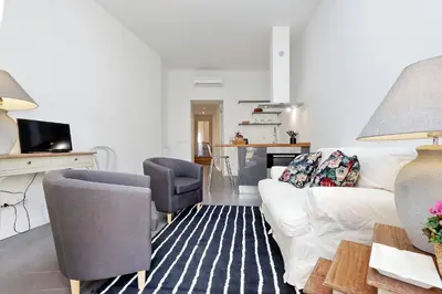 a living room with a white couch and a chair at Monti charming apartment - Rome short let Service in Rome
