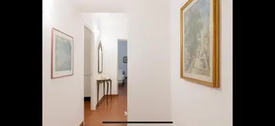 a hallway with two paintings on the wall and a table at IN FRONT OF COLISEUM 2 in Rome
