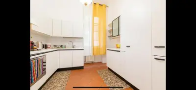 a kitchen with white cabinets and a tile floor at IN FRONT OF COLISEUM 2 in Rome