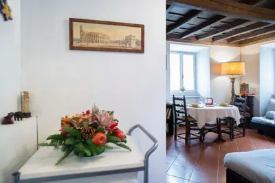 a living room with a table with a vase of flowers at Indimenticabili VACANZE ROMANE nel cuore della città in Rome