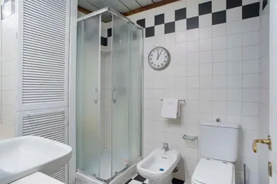 a bathroom with a shower and a toilet and a clock at Indimenticabili VACANZE ROMANE nel cuore della città in Rome