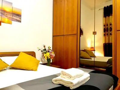 a bedroom with two beds with yellow pillows and a mirror at COLOSSEUM LUXURY ROOM in Rome