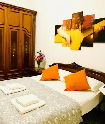 a bedroom with a bed with orange and white pillows at COLOSSEUM LUXURY ROOM in Rome