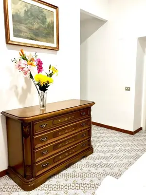 a vase of flowers on a dresser in a room at COLOSSEUM LUXURY ROOM in Rome