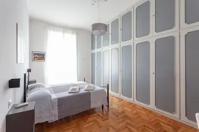 a bedroom with a bed and a large window at Il Melograno Holiday House in Rome