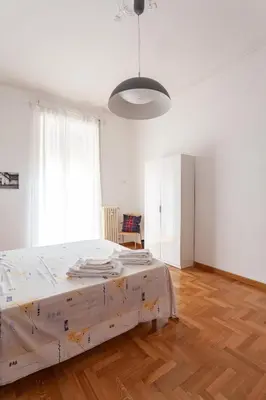 a bedroom with a large bed with a wooden floor at Il Melograno Holiday House in Rome
