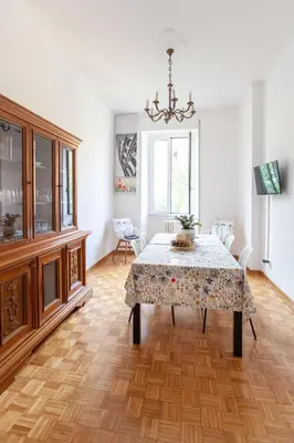 a dining room with a table and a chandelier at Il Melograno Holiday House in Rome