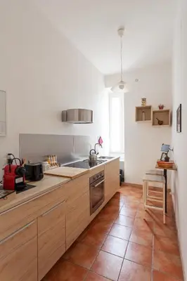 a kitchen with wooden cabinets and a counter top at Il Melograno Holiday House in Rome