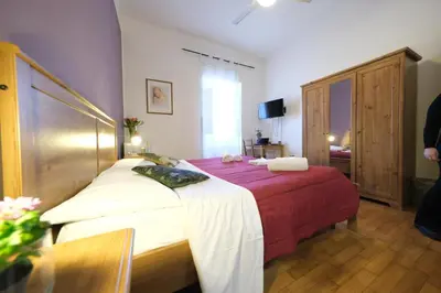 a bedroom with a bed with a red and white blanket at Gialel Guesthouse in Rome