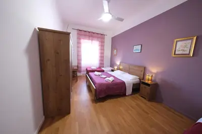 a bedroom with purple walls and a bed and a window at Gialel Guesthouse in Rome