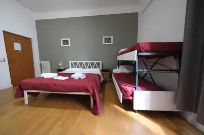 a bedroom with two bunk beds with red sheets at Gialel Guesthouse in Rome