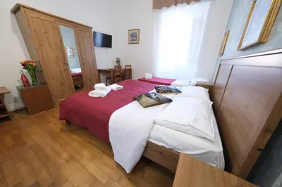a bedroom with a bed with red and white sheets at Gialel Guesthouse in Rome