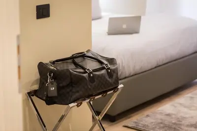 a bag sitting on a stool next to a bed at 126 Gracchi Suites in Rome