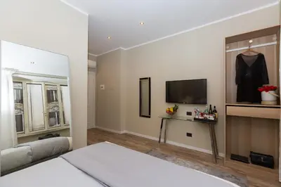a bedroom with a bed and a flat screen tv at 126 Gracchi Suites in Rome