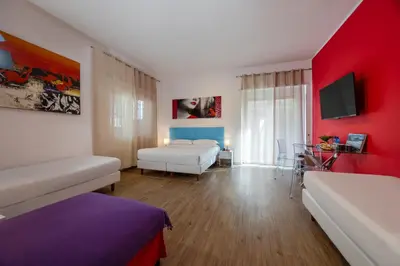 a bedroom with two beds and a red wall at Vaticano84 in Rome