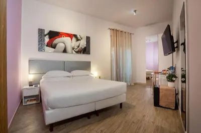 a bedroom with a white bed and a tv at Vaticano84 in Rome
