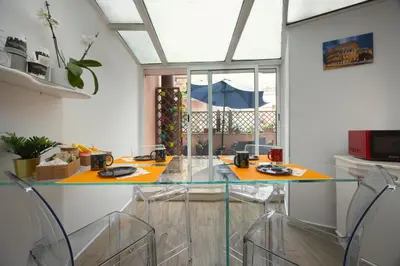 a dining room with a glass table and chairs at Vaticano84 in Rome