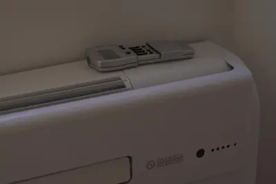 a washing machine with a remote control on top of it at Arcadia apartments in Rome