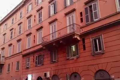 a red building with a balcony on the side of it at Arcadia apartments in Rome