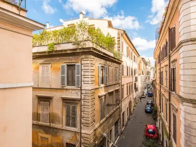 an alley with buildings and a red car on a street at Apartment Domus Fori by Interhome in Rome